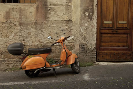 Scooter parked in a narrow old street of Rome photo