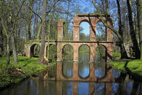 Antique aqueduc romain qui reflète dans une flaque d'eau photo